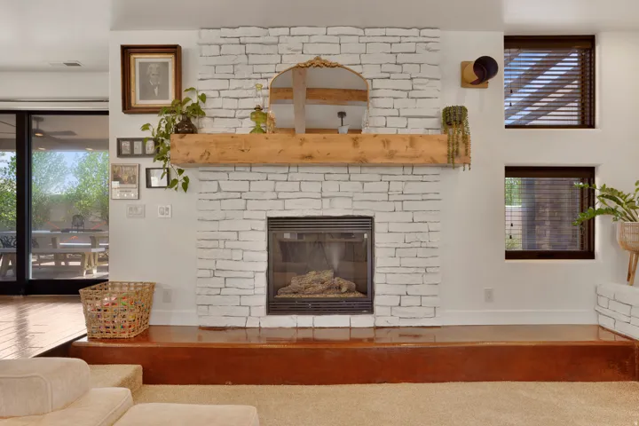 White-painted brick fireplace with a substantial wood mantel
