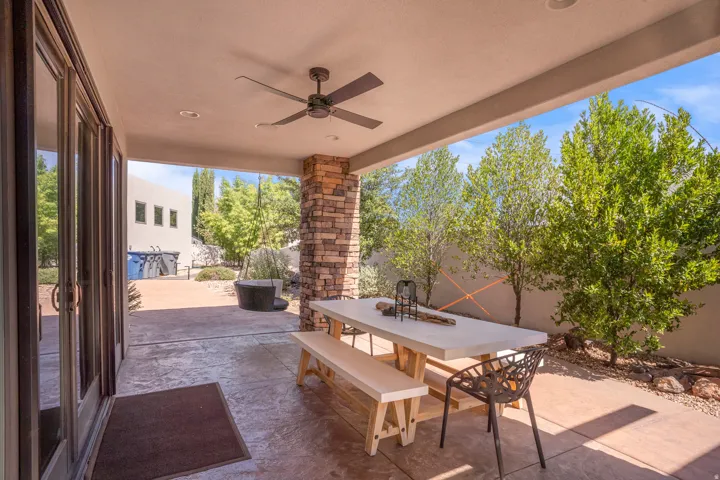 Covered patio with a ceiling fan, recessed lighting, a stone-clad pillar, and stamped concrete flooring