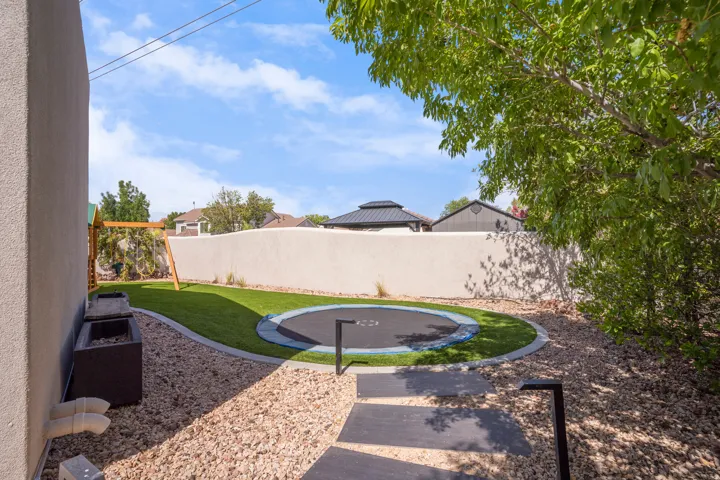 Backyard featuring a combination of artificial turf and gravel landscaping