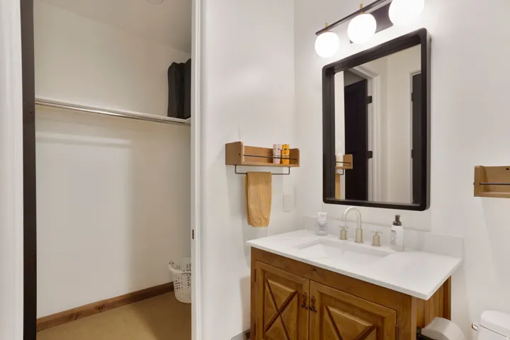 Bathroom vanity with a white countertop and wood-finish cabinetry
