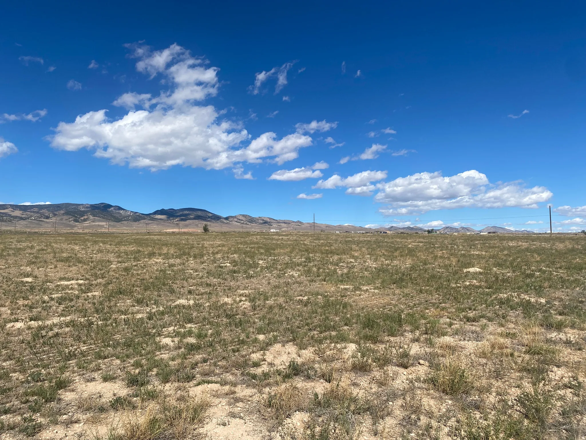 Expansive undeveloped land with a distant mountain range backdrop