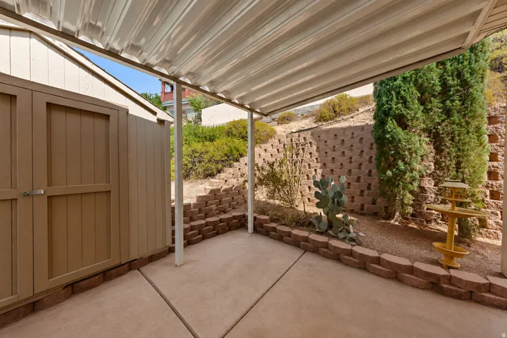 Covered patio featuring concrete flooring and a wood-sided storage shed