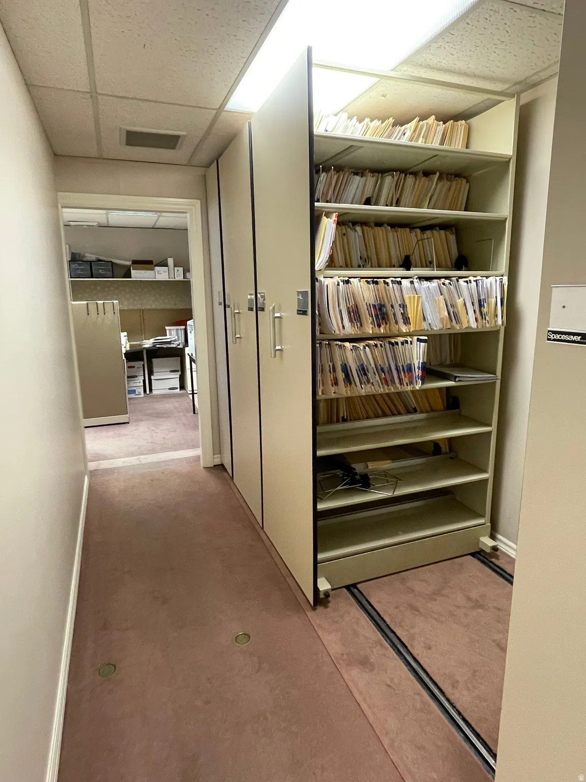 Floor-to-ceiling mobile shelving unit featuring a beige finish and multiple storage levels