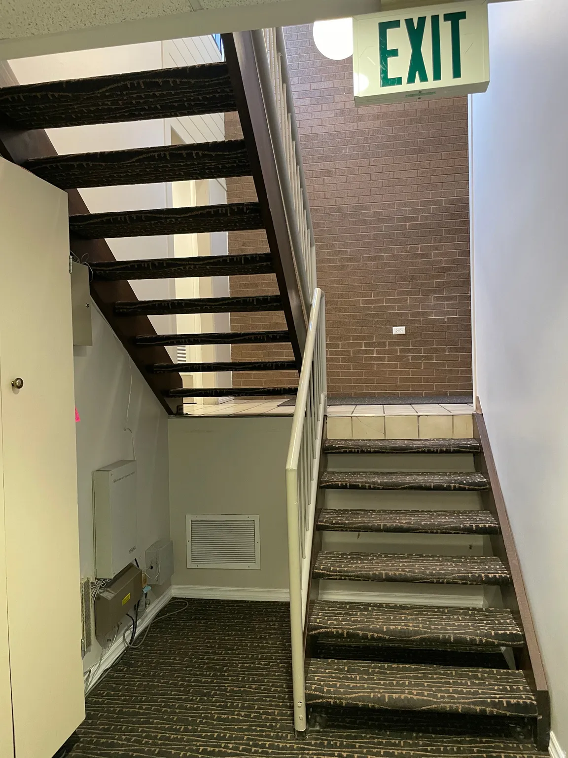 Carpeted staircase with white metal railings