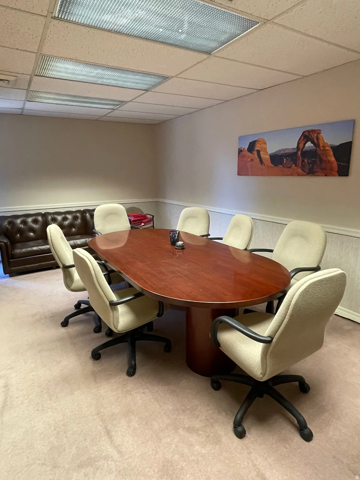 Conference room featuring a large wood-finish table, recessed lighting, and drop ceiling