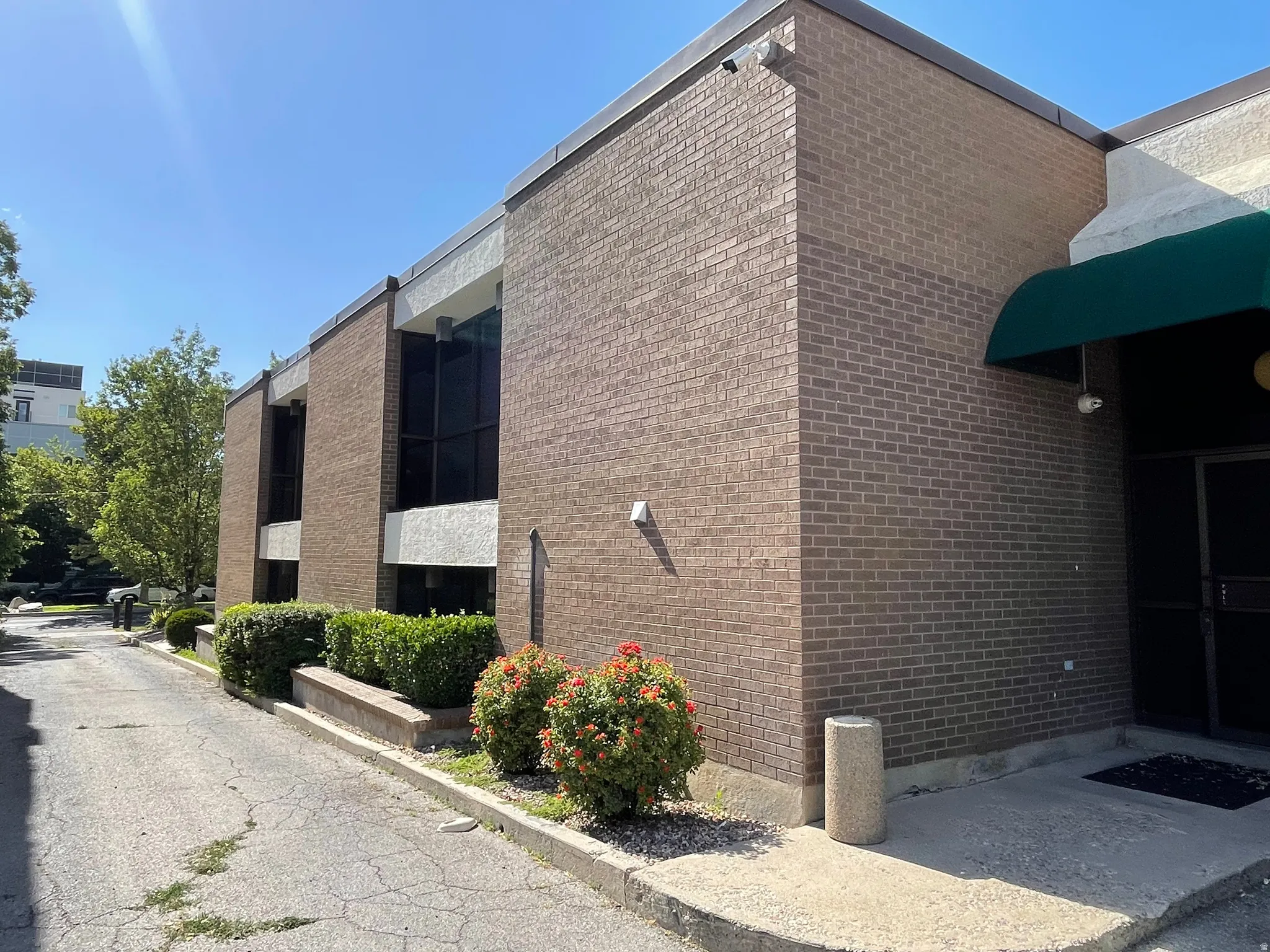 Brick exterior building featuring tinted windows and a green fabric awning