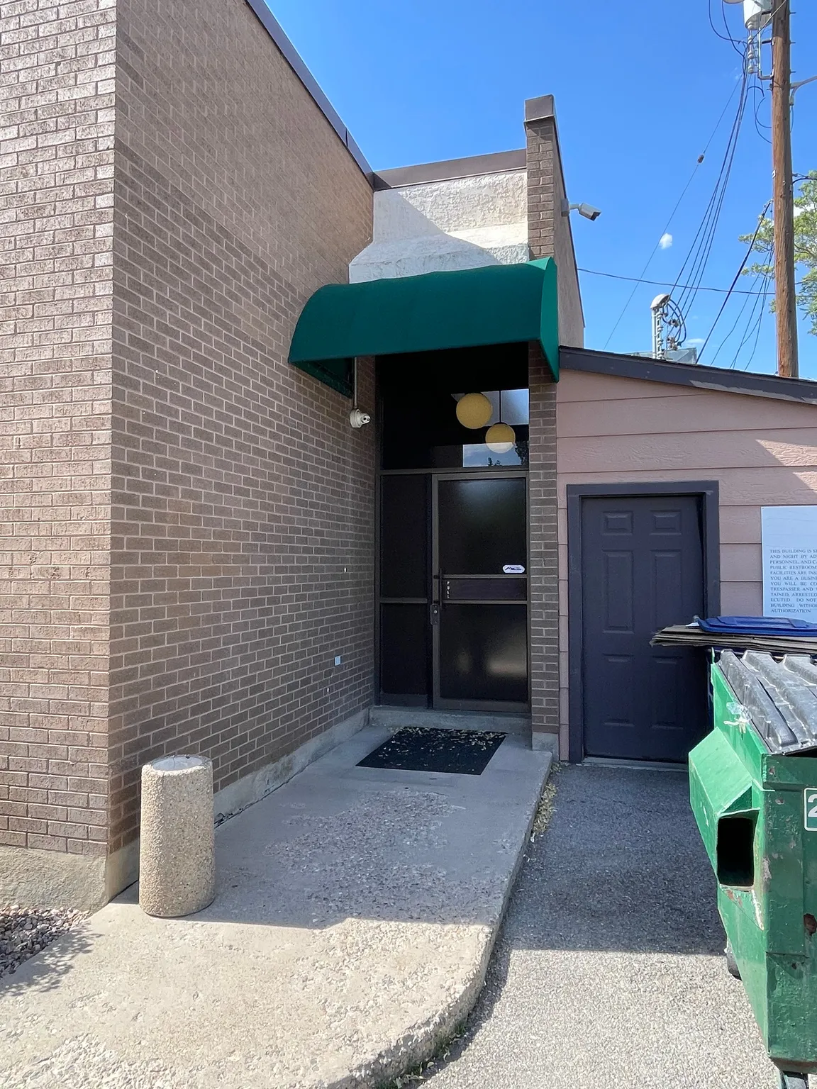 Brick exterior with a dark green awning over the main entrance