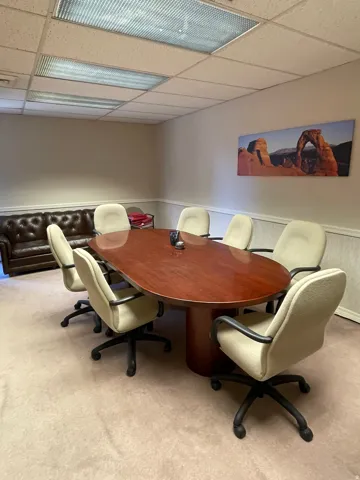 Conference room featuring a large wood-finish table, recessed lighting, and drop ceiling