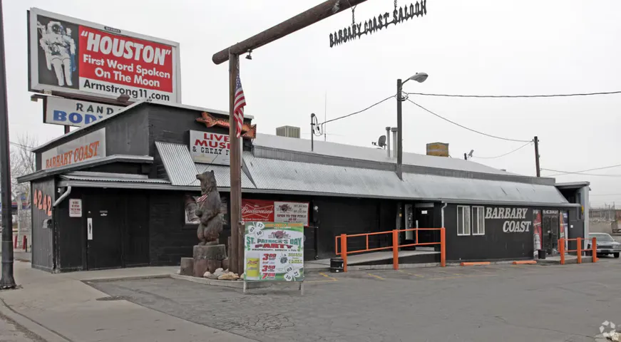 Single-story commercial building featuring black siding and a gray metal roof