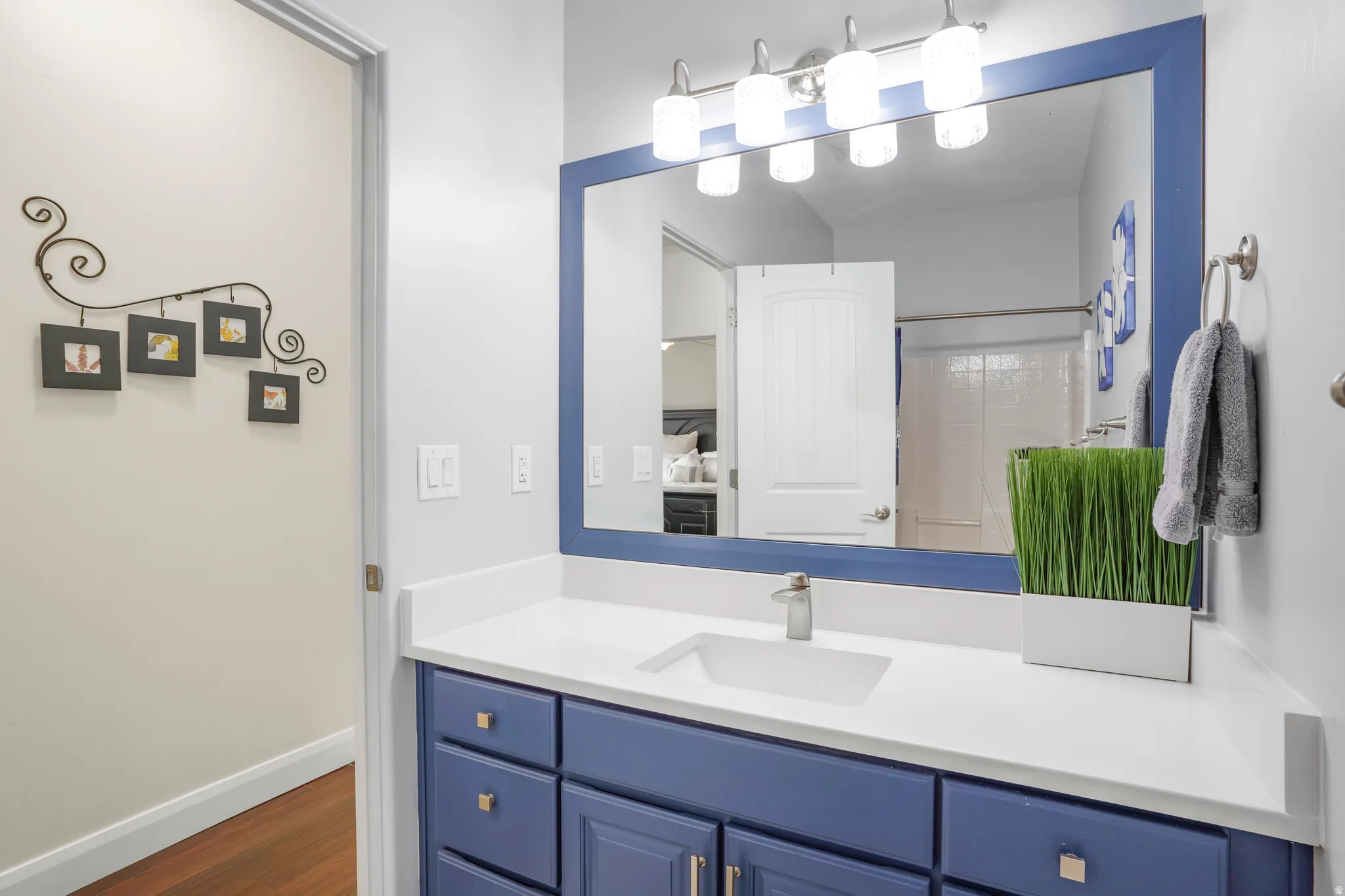 Bathroom vanity featuring a white countertop, under-mount sink, and blue cabinetry with brushed nickel hardware