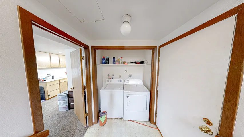 Dedicated laundry area featuring a white top-load washing machine and a white dryer