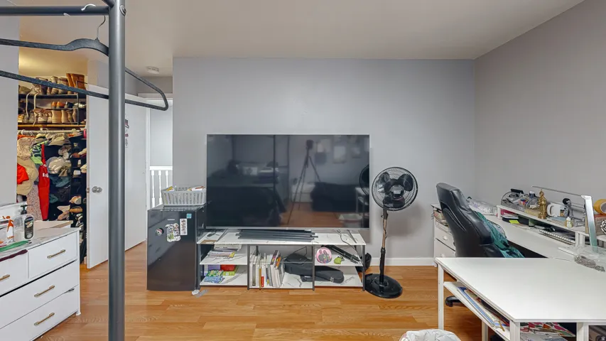 Interior space featuring wood-finish flooring, light grey painted walls, and white baseboards