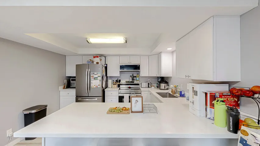 Modern kitchen featuring white cabinetry and light countertops