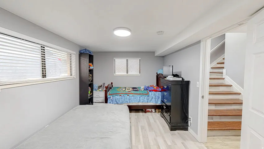 Recessed lighting illuminating a spacious room with light wood-finish flooring