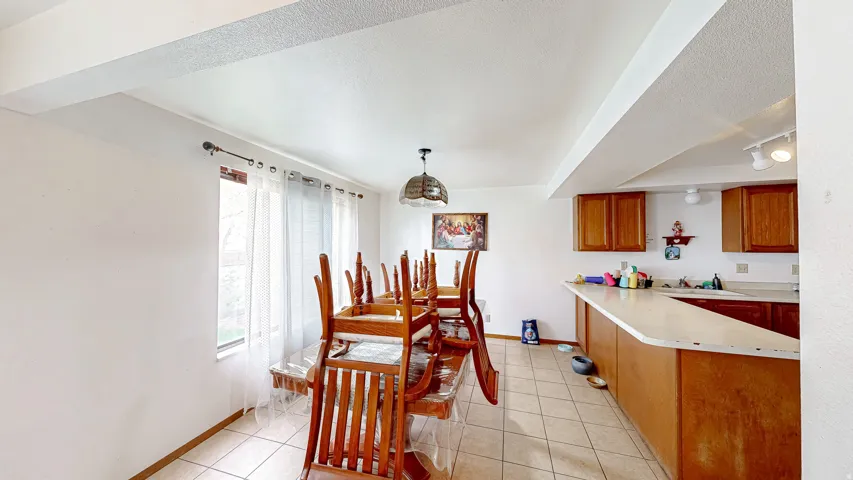 Open-concept dining area featuring tiled flooring and a dedicated lighting fixture