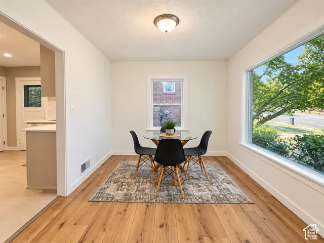 Recessed ceiling light fixture, wood-finish flooring, large picture window, white wall paint, and white trim