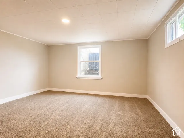 Bedroom with neutral tone walls complementing light brown carpeting