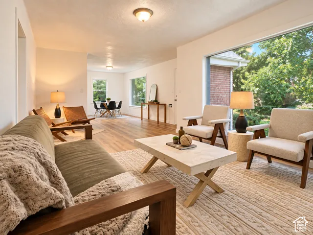Expansive floor-to-ceiling picture window, wood-finish flooring, recessed ceiling lighting, and a neutral color palette