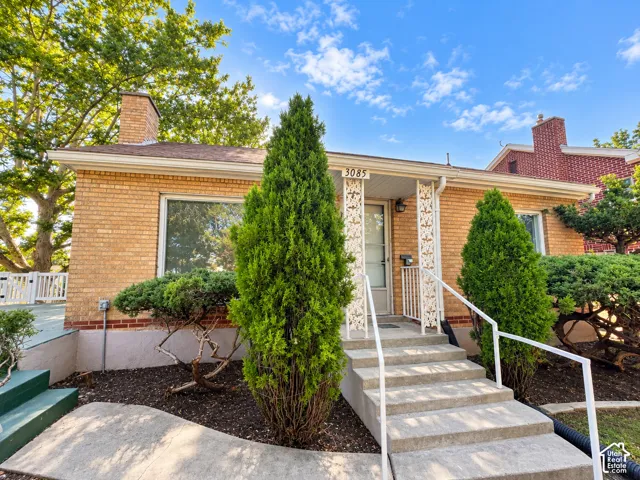 Brick exterior featuring a front entry with concrete steps and white railings