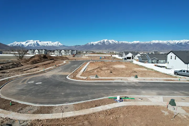Mountain backdrop, newly paved streets, established curbs, and visible utilities