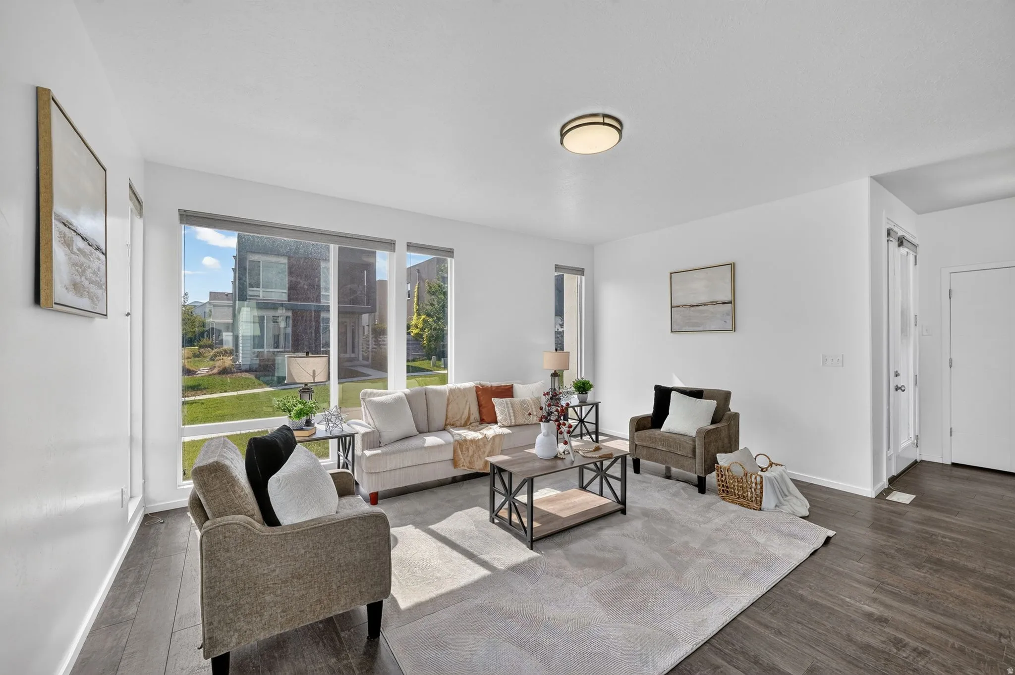 Living area featuring large windows, wood-finish flooring, recessed lighting, and a neutral color palette