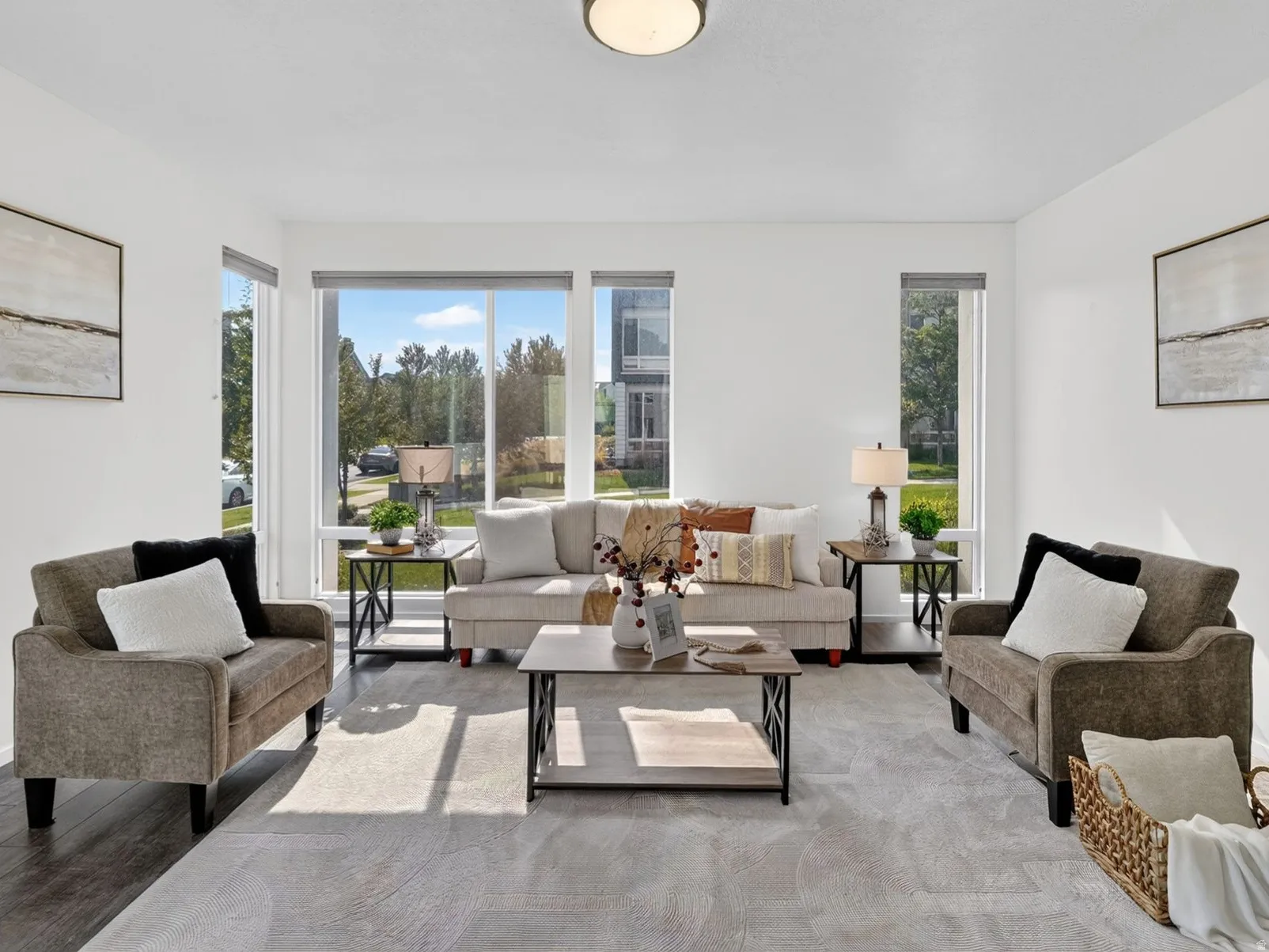 Spacious living area featuring large windows, dark wood-finish flooring, and recessed lighting