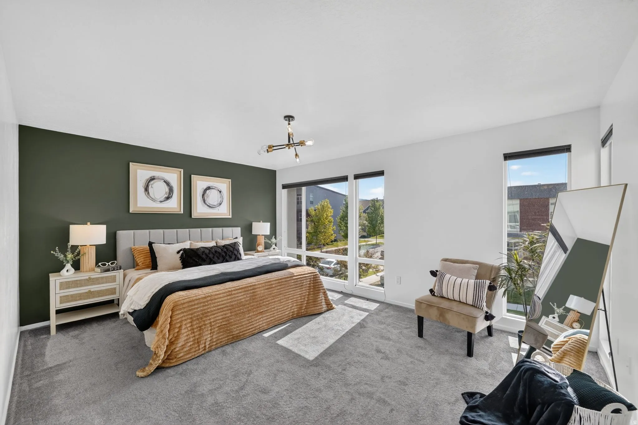Spacious room featuring a dark green accent wall, light grey carpeting, and large windows