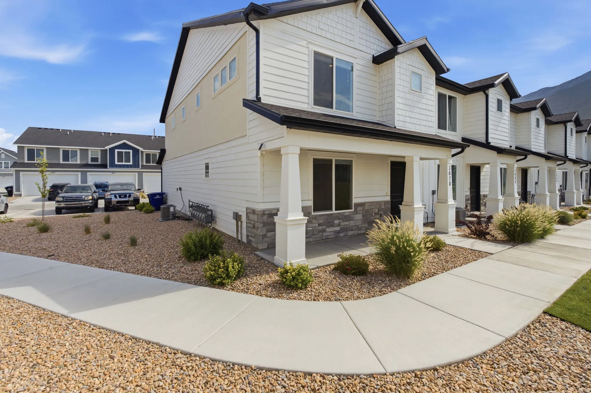 Contemporary townhome with a white siding and stone façade