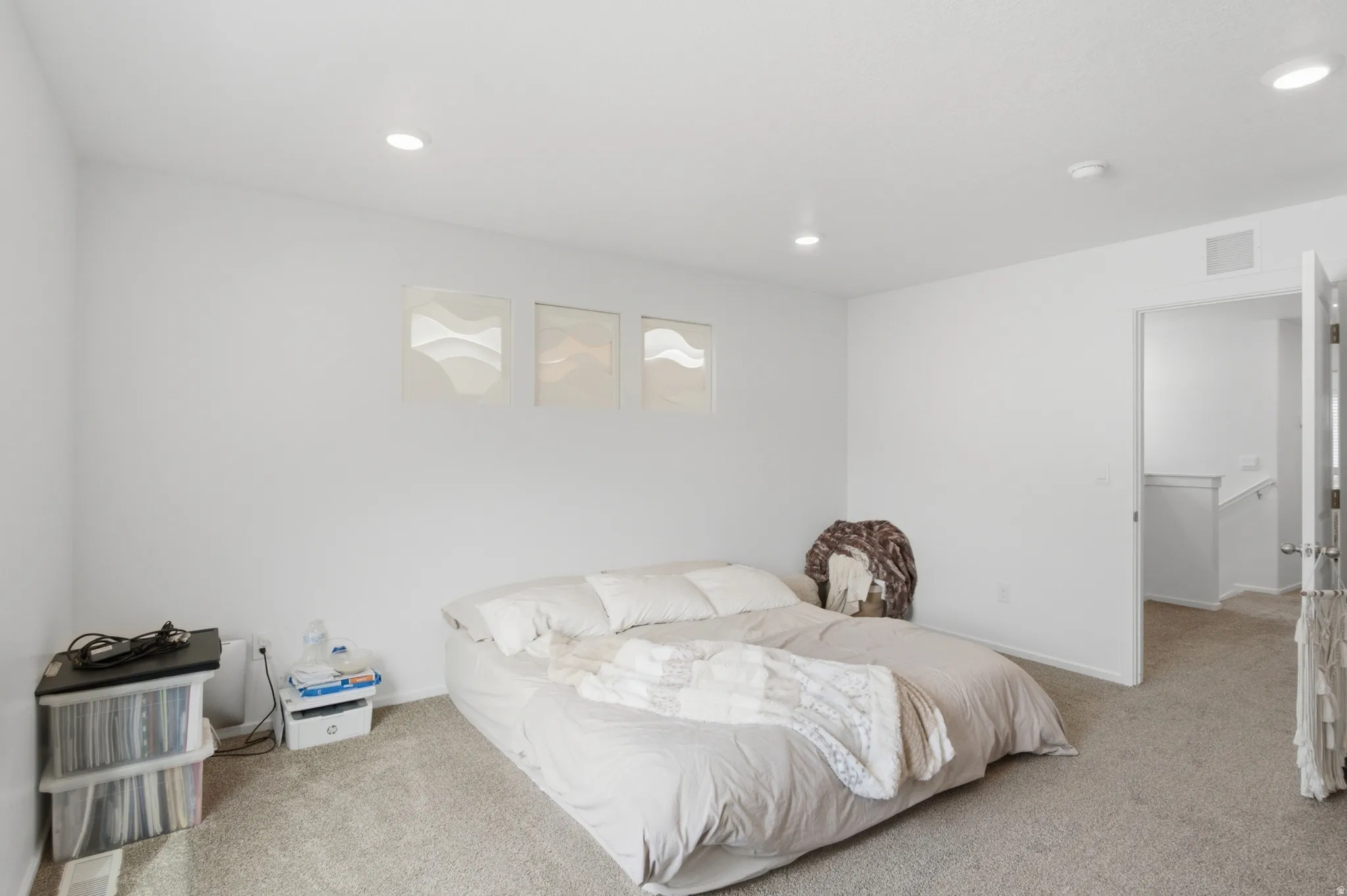 Spacious room featuring neutral carpet flooring, recessed lighting, and white painted walls