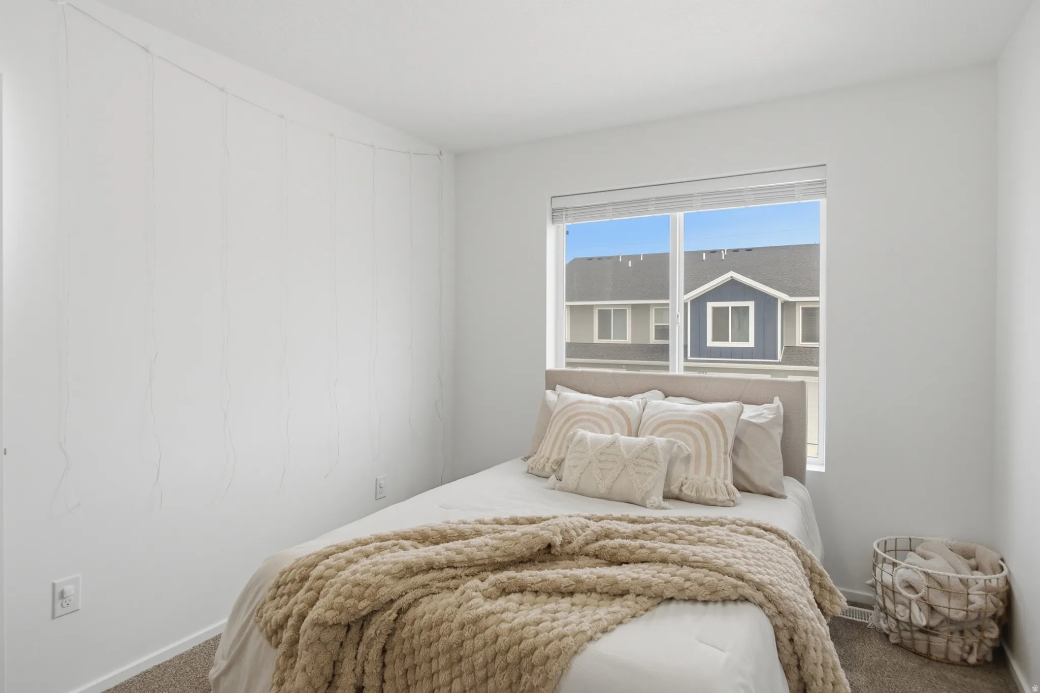 Carpeted bedroom with a large window featuring horizontal blinds