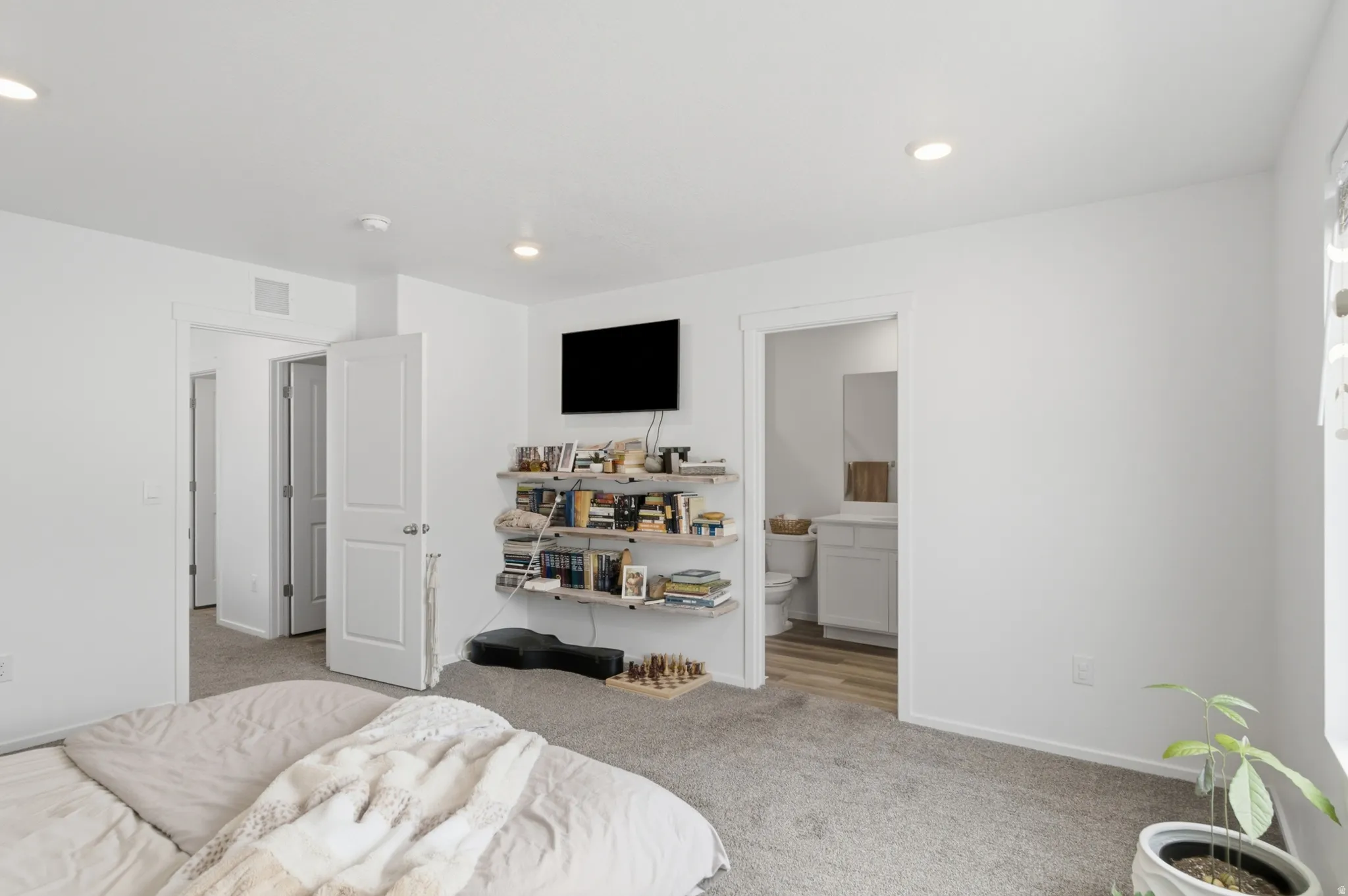 Light-filled room featuring plush grey carpeting and white painted walls