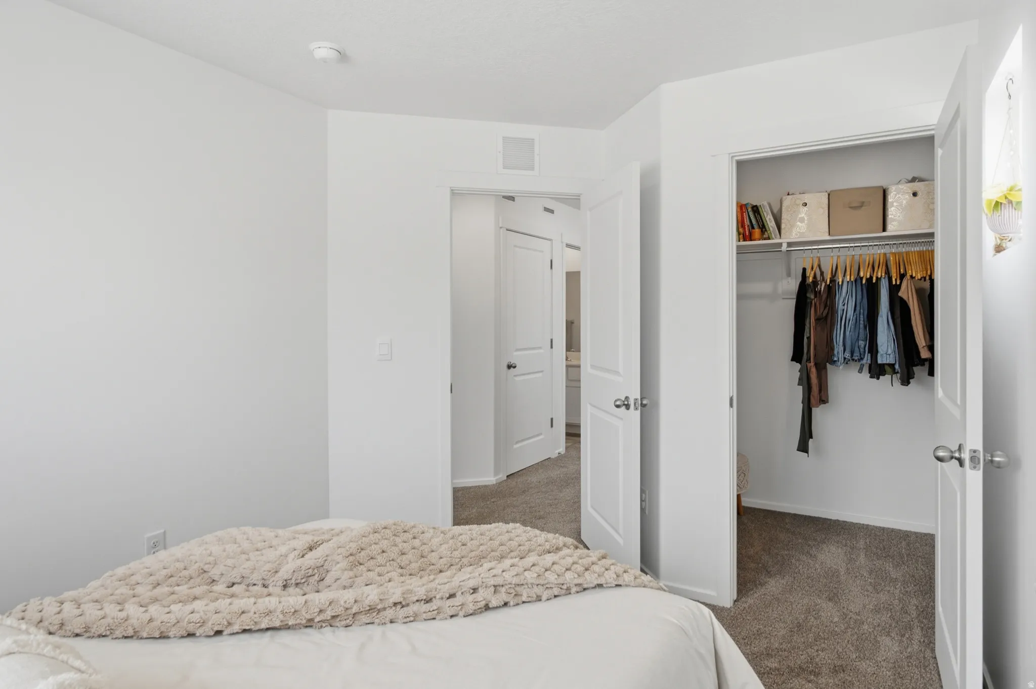 Bedroom featuring light gray carpeting, crisp white walls, and a recessed ceiling light