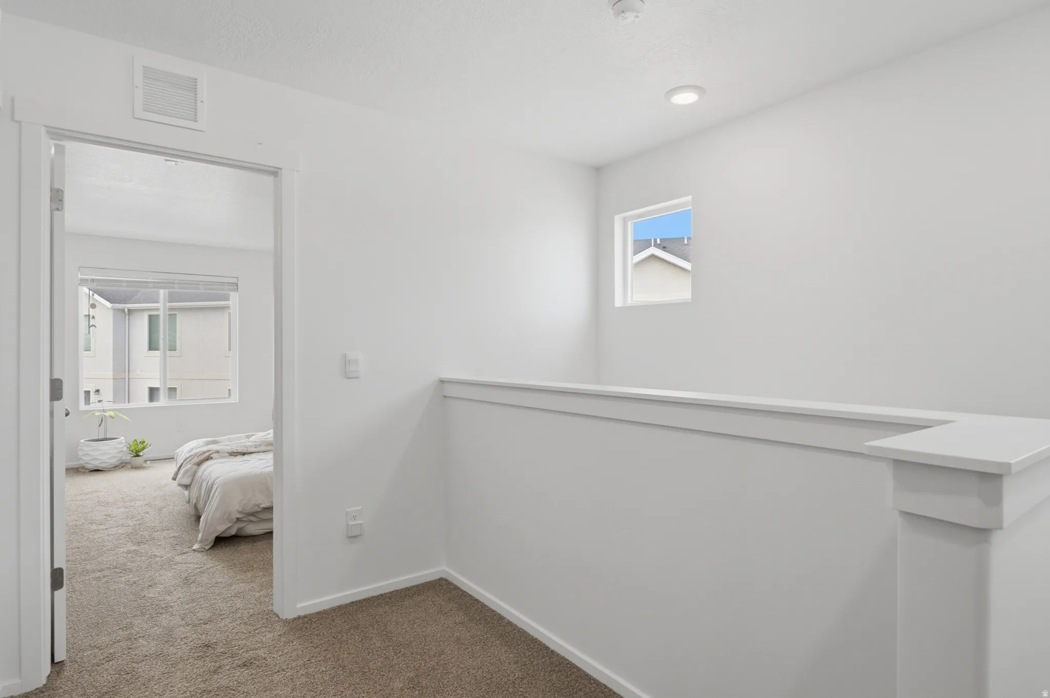 Upper-level landing with neutral carpet flooring and white walls