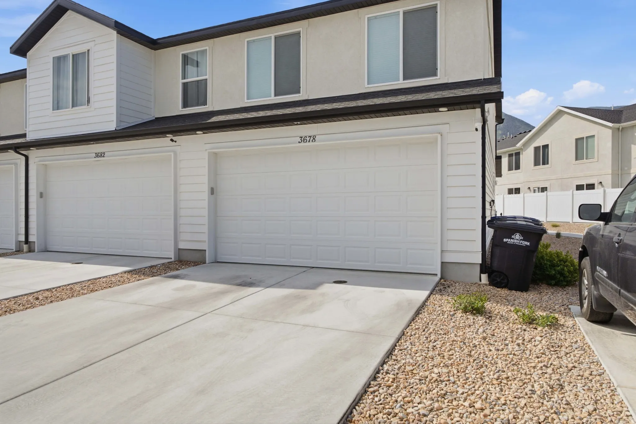Attached two-car garage with white paneled doors and overhead lighting