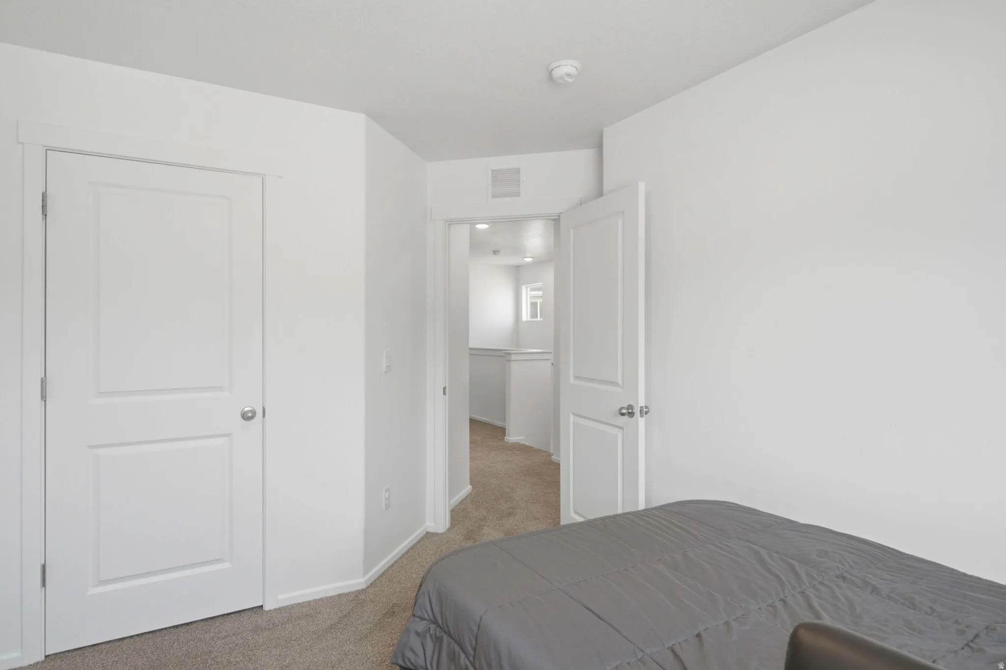 Clean interior space featuring light-colored walls and neutral carpeting