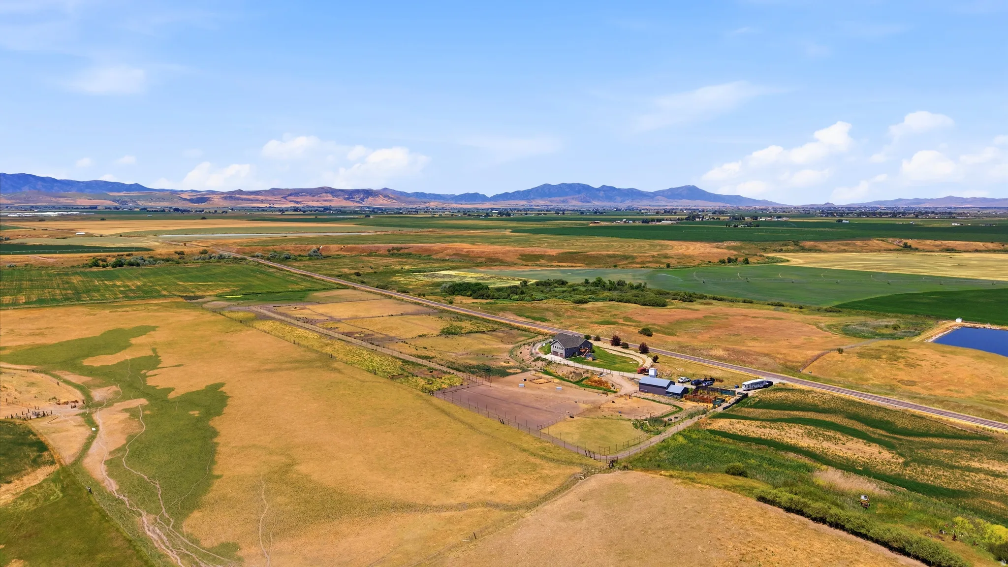 Expansive rural property featuring a main residence, multiple outbuildings, and a private pond