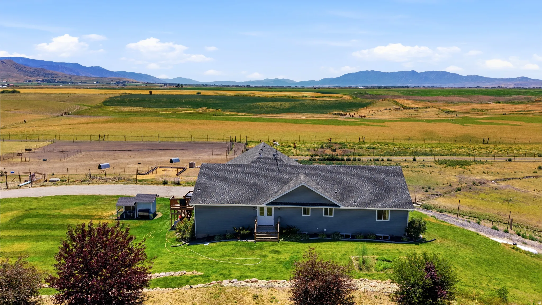 Ranch-style residence featuring a dark gray shingle roof and light blue siding