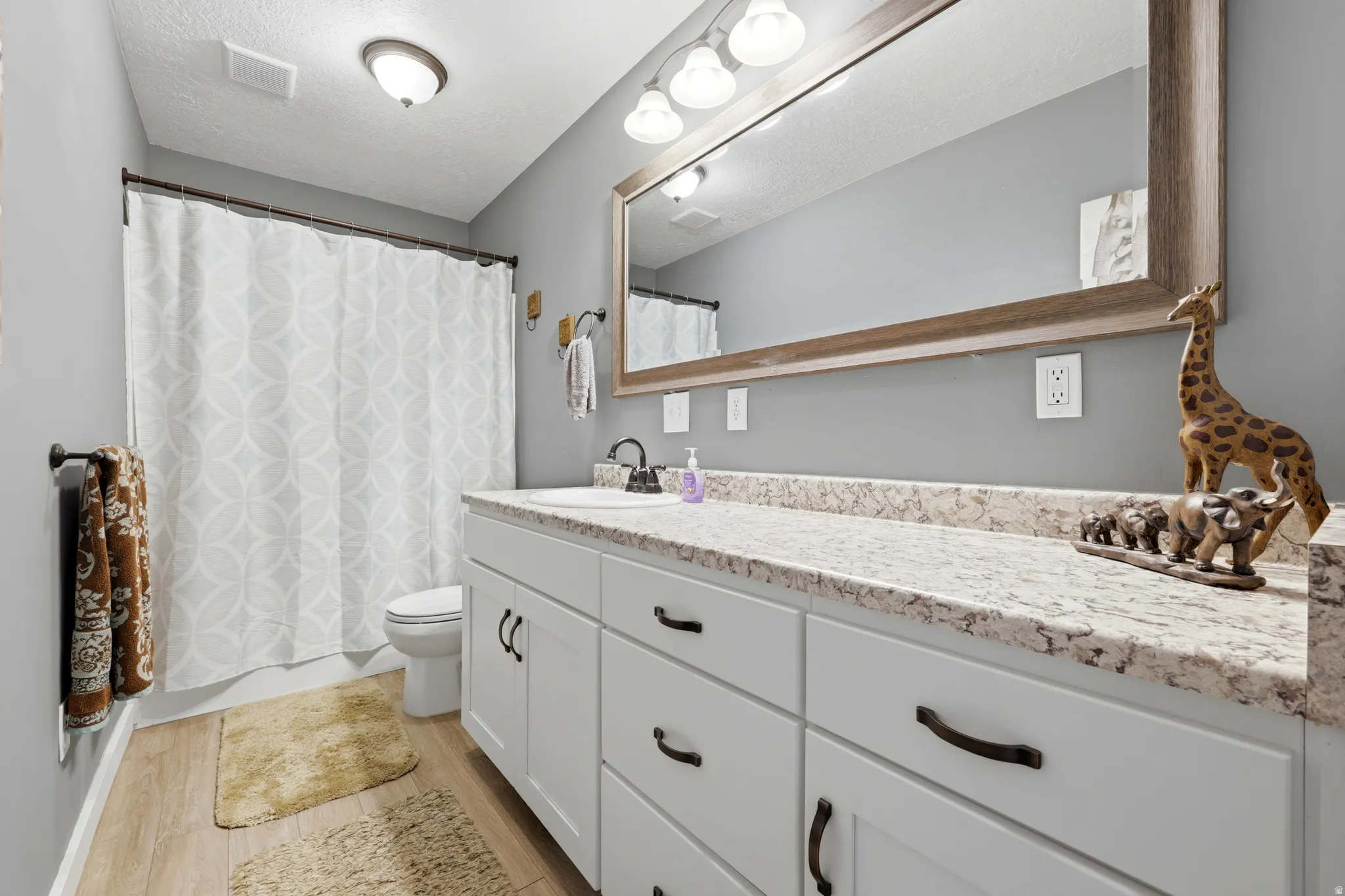 Double vanity with light-colored countertop and integrated sink