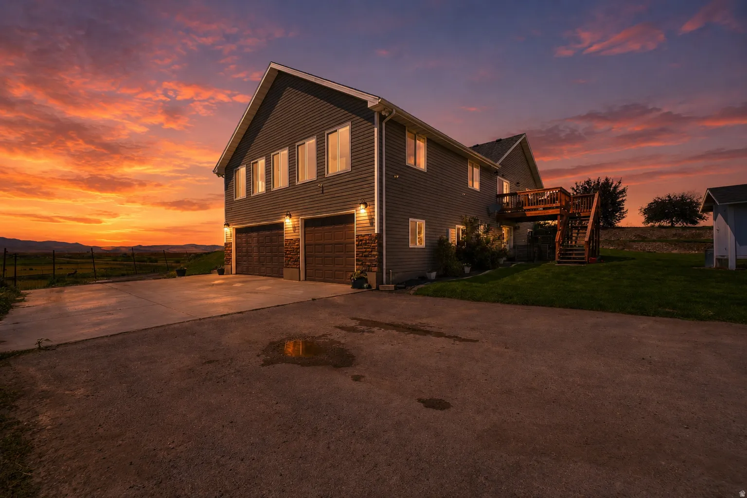 Two-story residence featuring grey siding and stone accents on the lower level