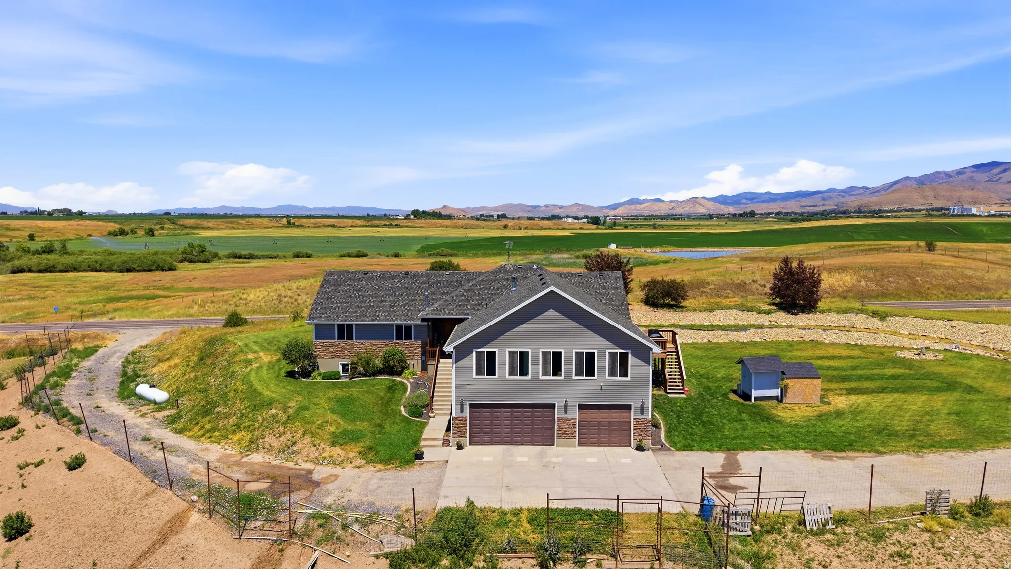 Expansive property featuring a two-story residence with a gray siding exterior and multiple windows