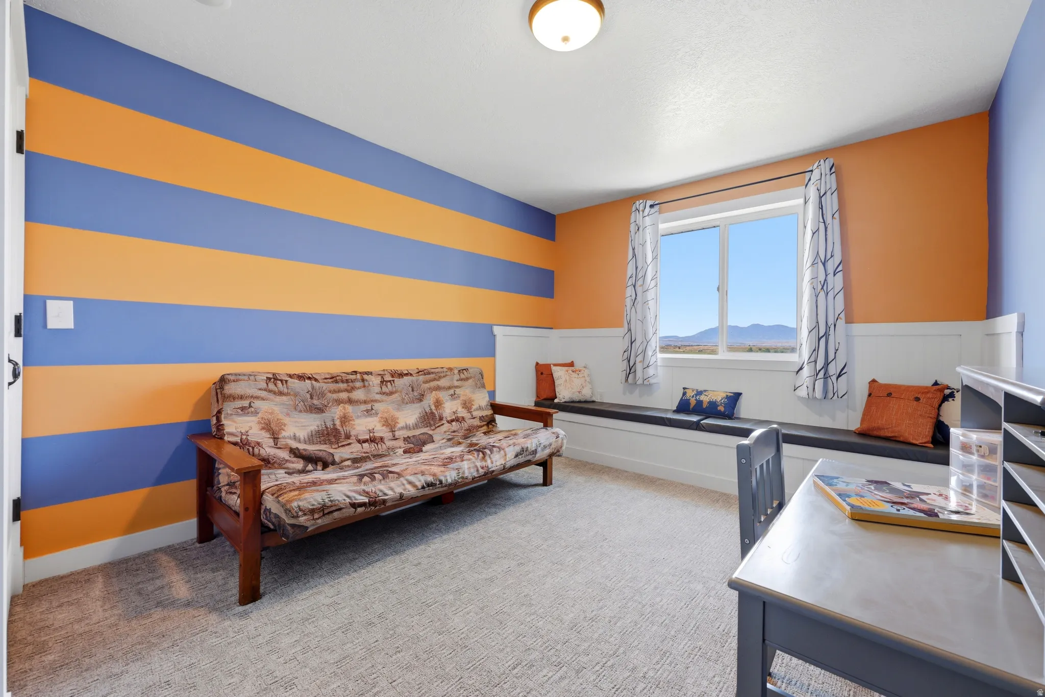 Room featuring a built-in window bench, a large single window, and a carpeted floor