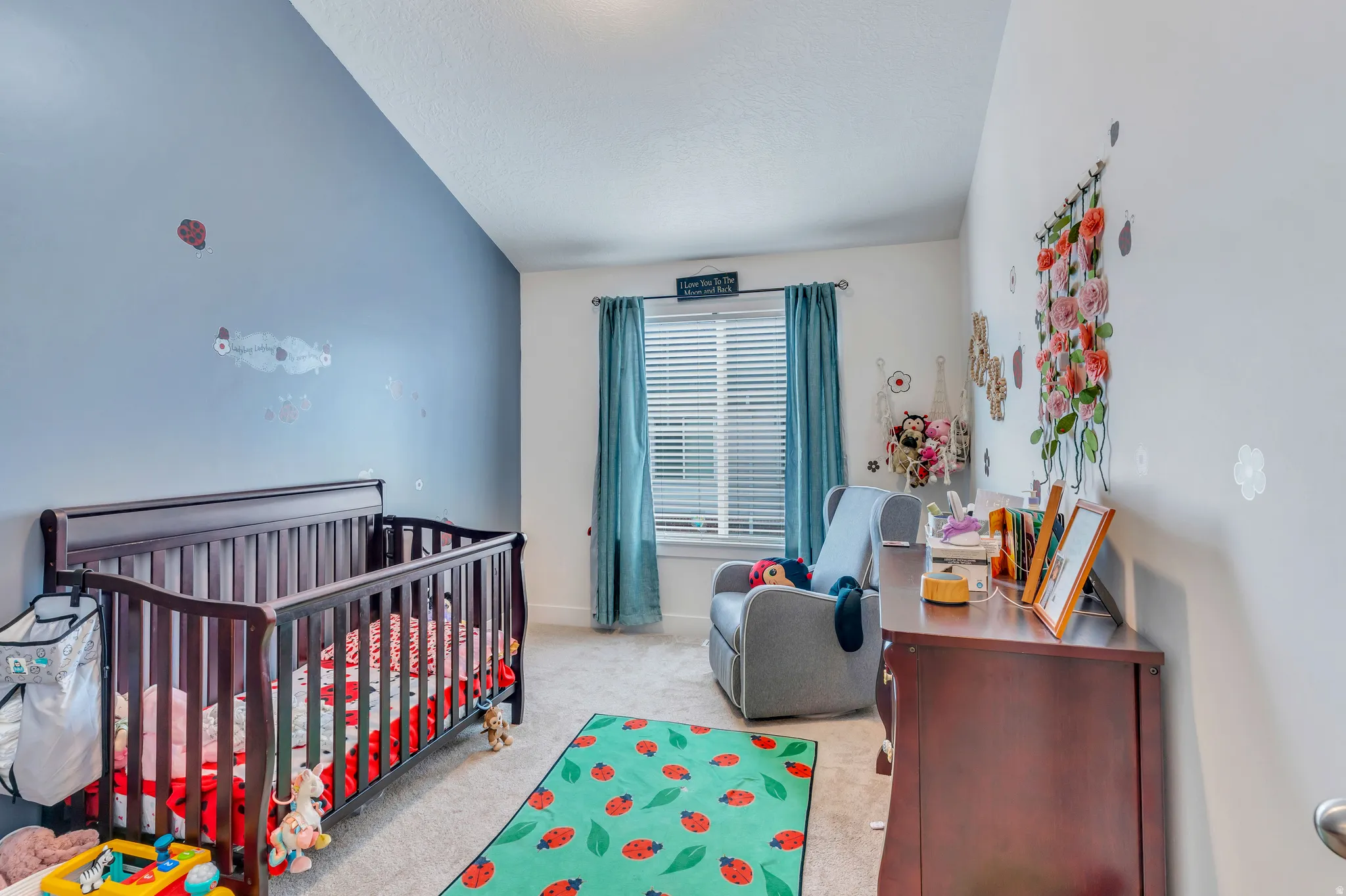 Bedroom featuring a window with blinds, carpet flooring, and a single ceiling light fixture
