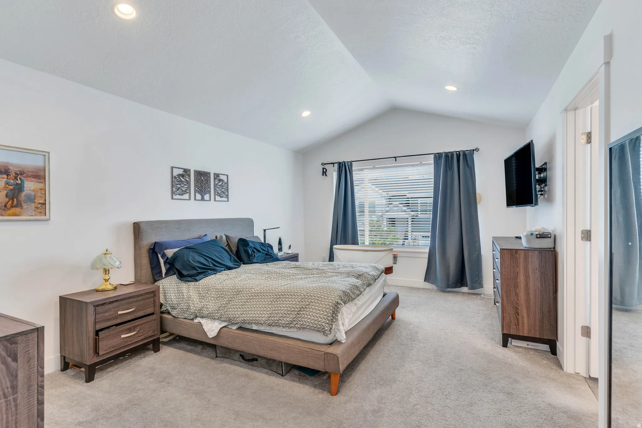 Vaulted ceiling bedroom featuring recessed lighting, a large window with blinds, and light gray carpet flooring