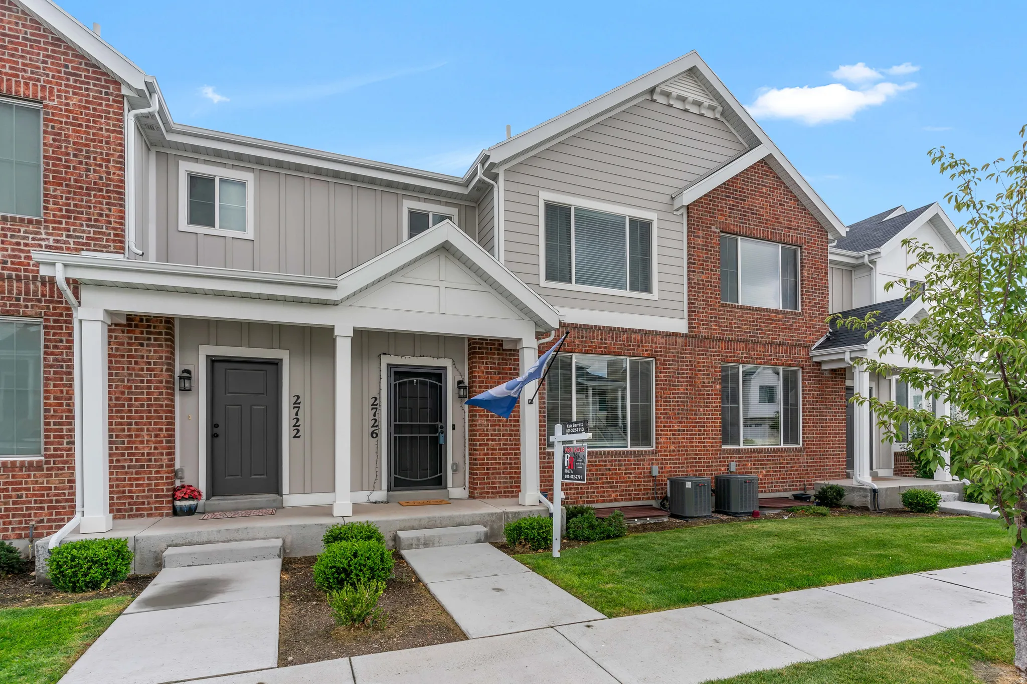 Multi-level townhome exterior featuring brick and vertical siding accents