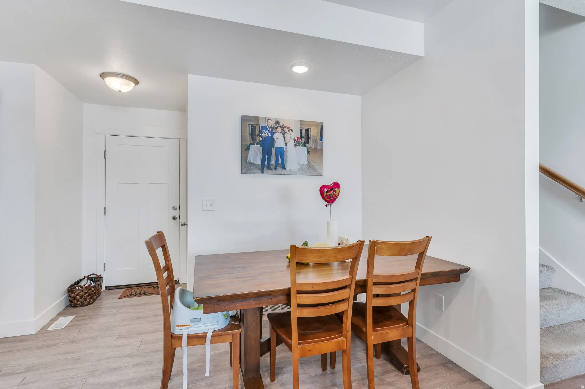Entry area featuring light wood-finish flooring, a white paneled door, and a flush mount ceiling light