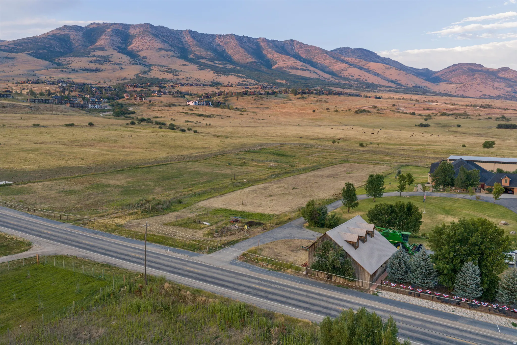 Expansive rural landscape featuring a single-story structure with a metal roof and multiple gabled dormers