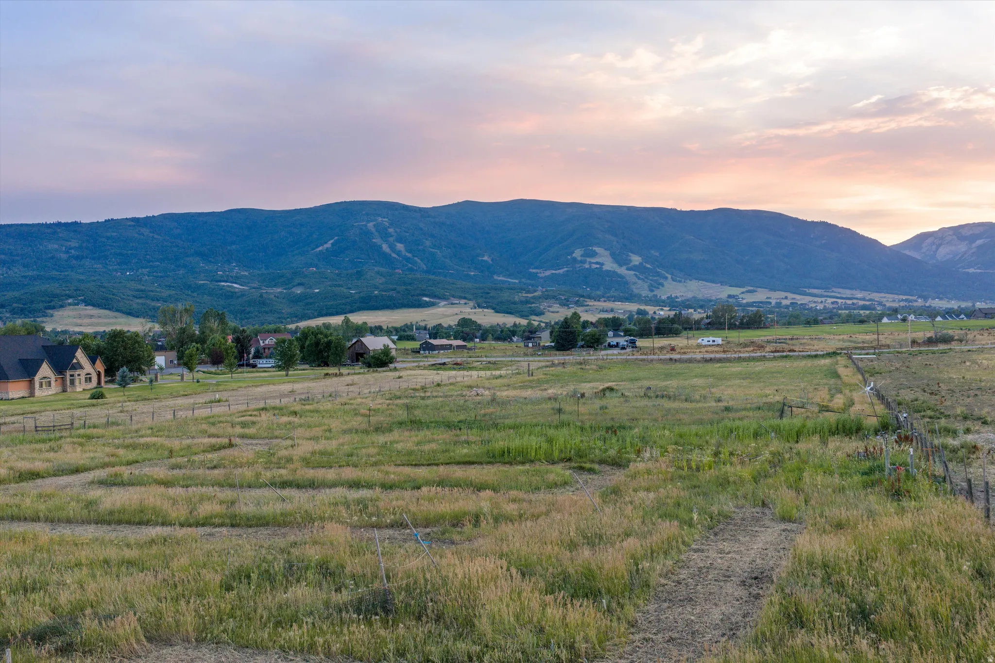 Expansive undeveloped land featuring natural grasses and distant mountain formations