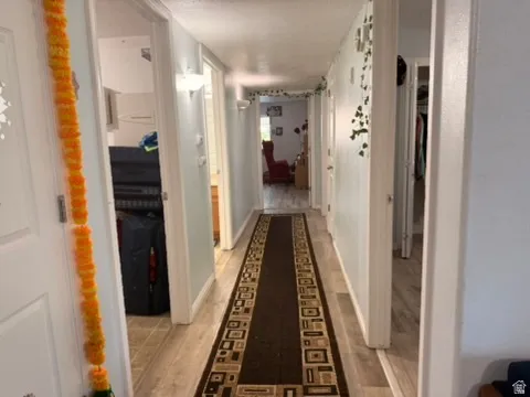 Hallway featuring wood-finish flooring and light-colored walls