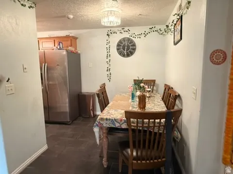 Dining area featuring dark flooring, a crystal chandelier, and a built-in kitchen cabinet