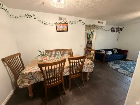 Dining area featuring dark wood-finish flooring, a ceiling-mounted light fixture, and white painted walls